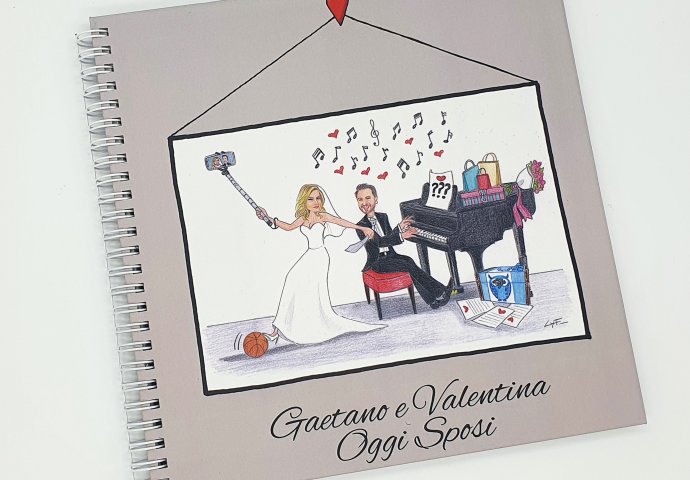 Guest book con rilegatura a spirale e stampa disegno caricatura fedele di sposa che fa un selfie al suo sposo mentre suona il piano.