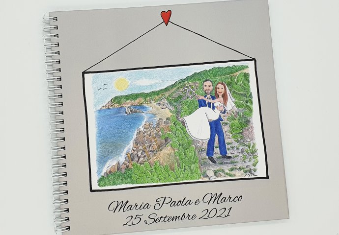 Guest book con rilegatura a spirale e stampa disegno caricatura fedele di sposa in braccio allo sposo. Nello sfondo il mare.